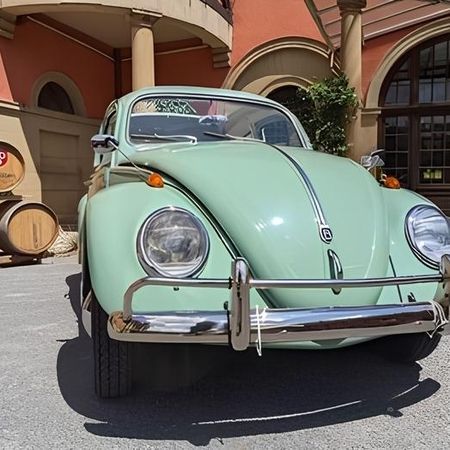 Ein türkiser VW Käfer steht auf einer Straße.