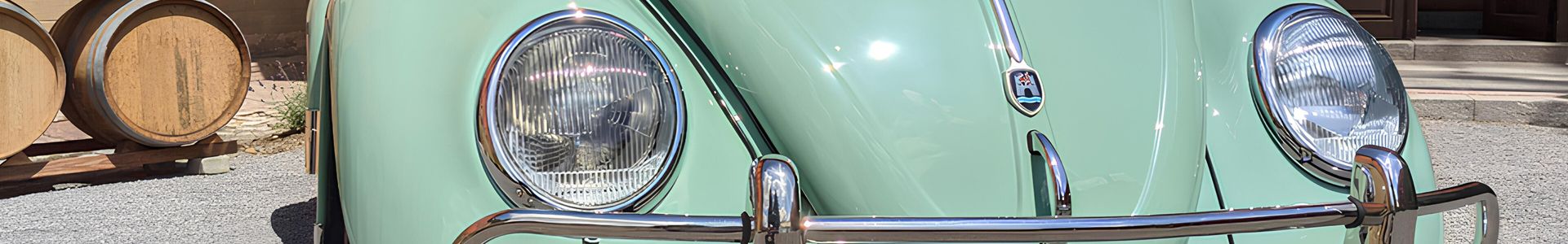 Ein türkiser VW Käfer steht auf einer Straße.